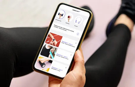 Une personne regarde divers exercices sur son téléphone cellulaire.