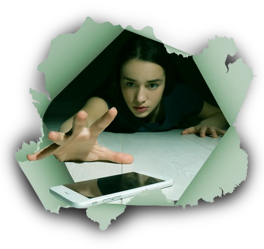 Une jeune femme tente d’attraper un téléphone cellulaire qui est loin d’elle.