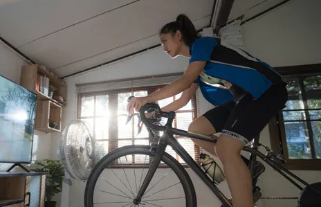 Une femme s’exerce sur un vélo d’intérieur.
