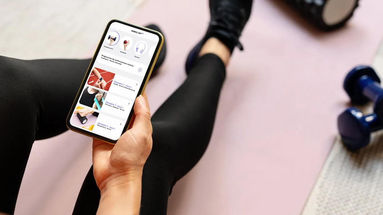Une personne regarde divers exercices sur son téléphone cellulaire.