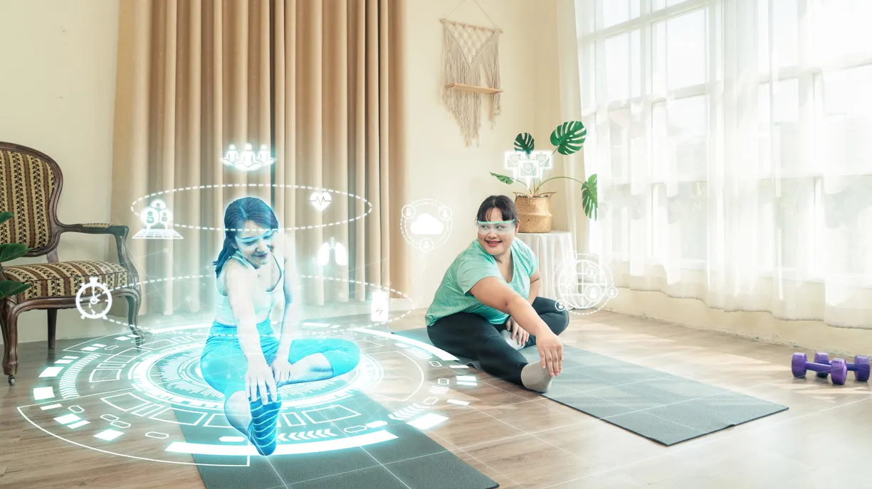 Une personne s’exerce en regardant un hologramme montrant une femme qui fait un étirement. Il y a plusieurs icônes autour de la femme de l’hologramme.