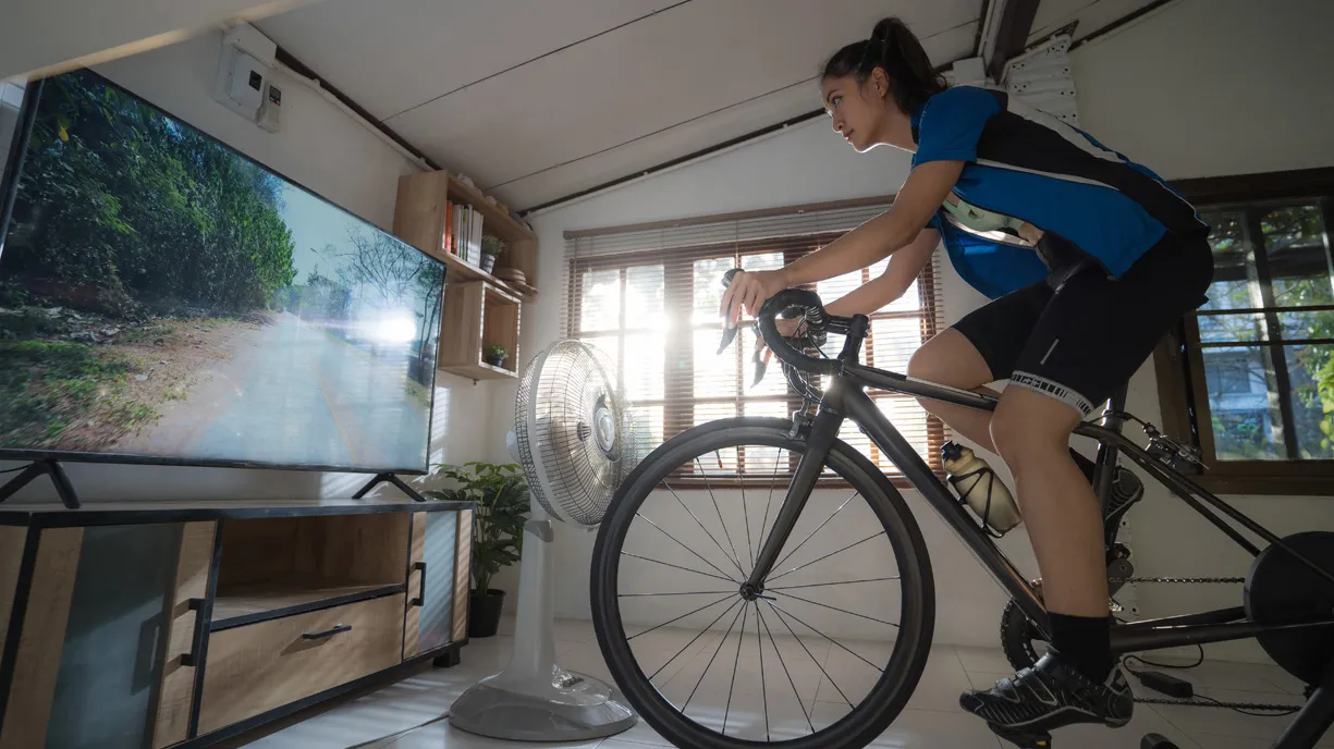 Une femme s’exerce sur un vélo d’intérieur.